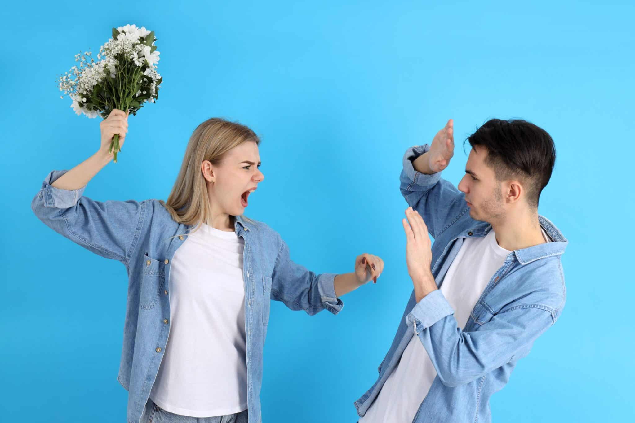 young couple fighting on a blue background